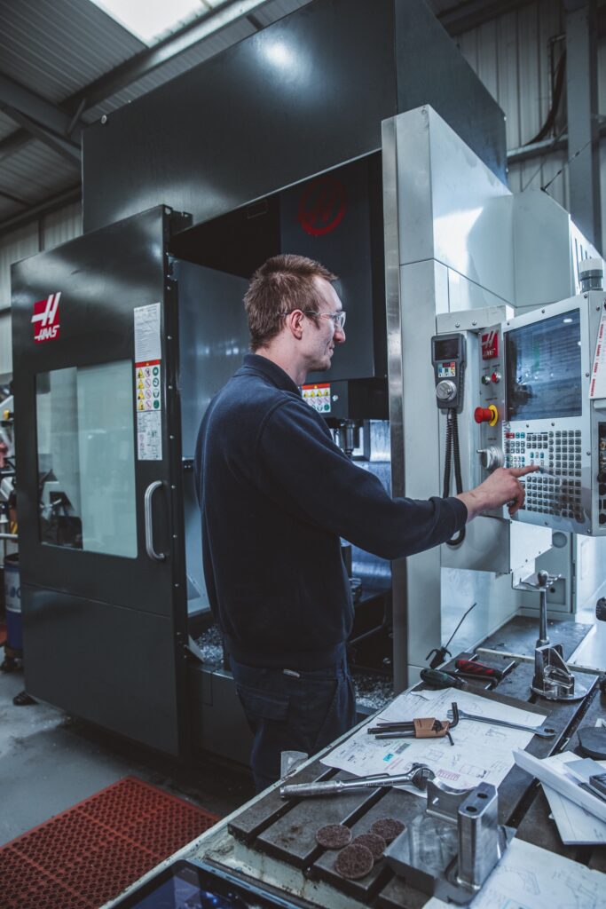 An engineer operates a CNC machine